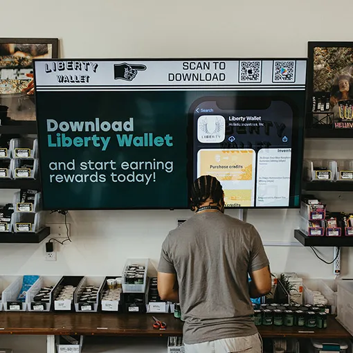 Liberty-Wallet-App Hands holding a phone featuring Liberty Wallet app